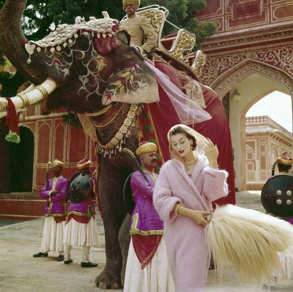 Anne Gunning in a pink mohair coat outside the City Palace Jaipur NORMAN PARKINSON VOGUE 1956